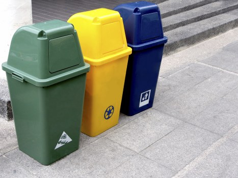 Recycling bins with separated paper and plastic in a business yard